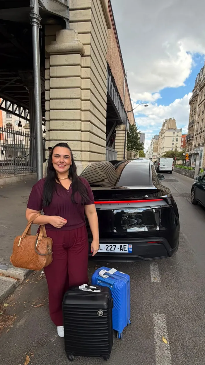 Cliente brasileira com malas ao lado do veículo em Paris